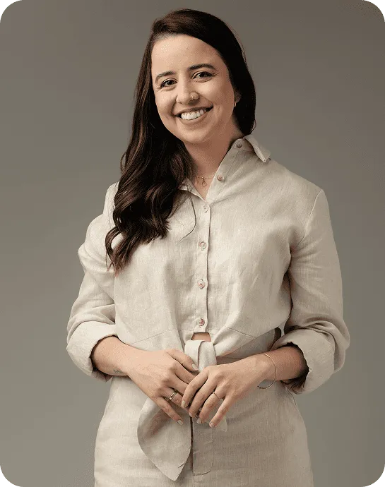 Dra. Larissa Negrão Ferreira sorrindo, em conjunto de linho claro, retrato de estúdio sobre fundo taupe